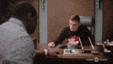 a man sits at a desk with a name plate that says rick