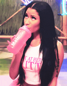 a woman is drinking from a pink bottle that says matefit