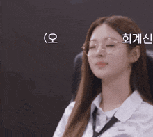 a woman wearing glasses and a white shirt is sitting in a chair