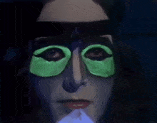 a close up of a woman 's face with glow in the dark eye patches .