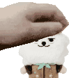 a person is petting a stuffed animal with a hat on .