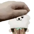 a person is petting a stuffed animal with a hat on .
