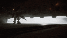 a robot is standing in a dark room with a light shining through a doorway