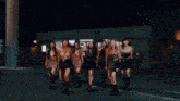 a group of girls dancing in front of a grocery store
