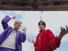 a man in a purple suit and a man in a red shirt are dancing together