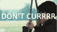 a person is sitting on a swing with the words do n't currrr written above them .