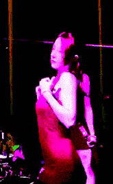 a woman in a pink dress is holding a purple object