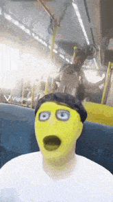 a man wearing a yellow mask is sitting on a bus with a viggle.ai logo in the corner