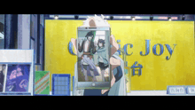 a person holding a cell phone in front of a yellow wall that says music joy