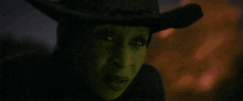 a close up of a person wearing a cowboy hat in the dark