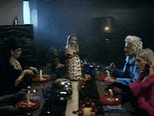a group of women sitting around a table with plates of food on it