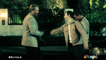 a nbc advertisement for suits la shows three men shaking hands
