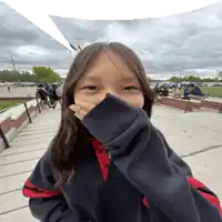 a girl covering her face with her sleeve while standing on stairs