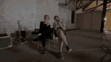 a man and woman are giving the middle finger to the camera .