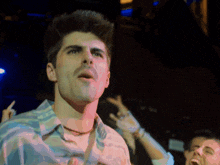 a man in a blue and white shirt with the letter b on the collar