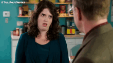 a woman is making a funny face while talking to a man .