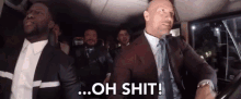 a group of men in suits and ties are riding in a car and one of them is saying `` oh shit ! ''