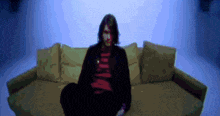 a pixelated image of a man sitting on a couch with a red shirt that says nirvana