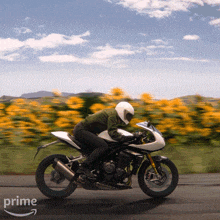 a person riding a motorcycle on a road with the word prime on the bottom right