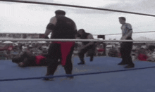 a referee watches a wrestling match between two men