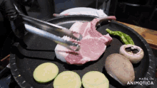 a steak is being cooked in a pan with vegetables and the words made in animotica on the bottom right