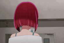 a girl with red hair is standing in front of a white wall