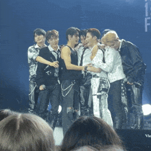 a group of men standing on a stage in front of a mic that says victor