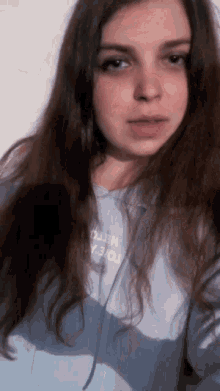 a girl with long hair is wearing a light blue hoodie that says hello on it