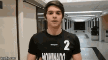 a young man wearing a black shirt with the number 2 on it .