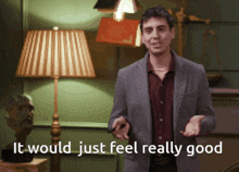 a man in a suit stands in front of a lamp with the words it would just feel really good below him