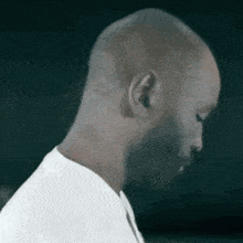 a man with a beard and a white shirt is looking down at something .