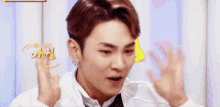 a young man in a white shirt and tie is making a funny face with his hands .