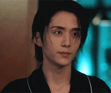 a close up of a young man 's face with a black shirt on
