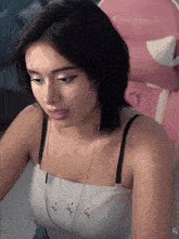 a woman wearing headphones is sitting in a pink chair with the letter xg on the bottom