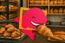 a pink dolphin is holding a croissant in front of a display of croissants