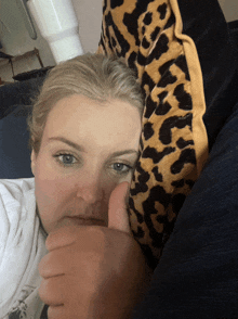 a woman gives a thumbs up while laying on a couch