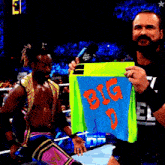a wrestler is holding up a blue shirt that says big d