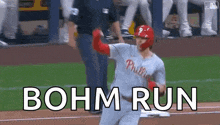 a baseball player is running towards home plate with the words bohm run written on the ground .