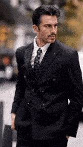 a man in a suit and tie is standing on a street .