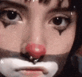 a close up of a person 's face with a clown makeup on .