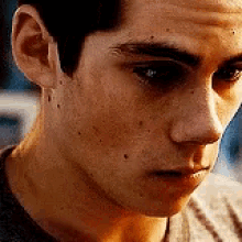 a close up of a man 's face with a gray shirt on