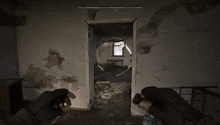 a person is holding a gun in a room with a doorway .