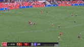 a soccer game is being played on a field with people first bank banners on the sidelines