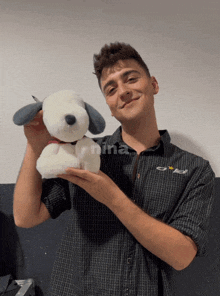 a man in a plaid shirt holds a stuffed animal in his hand