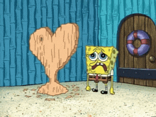 spongebob is standing in front of a heart shaped sculpture