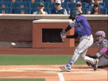 a baseball player wearing a purple jersey with the number 14