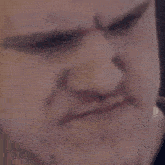 a close up of a man 's face with a serious expression .