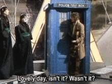 a man standing in front of a police box with the words lovely day isn 't it wasn 't it