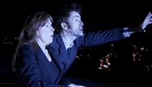 a man and a woman are looking up at something