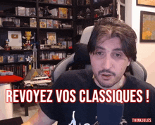 a man sitting in a chair with the words revoyez vos classiques written in red